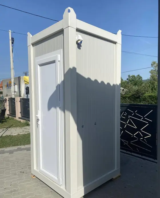 Large white single restroom cabin with a wide door, set on pavement